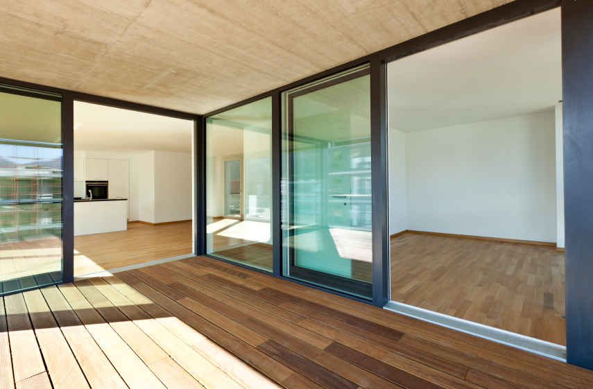 Indoor-outdoor living, glass walls open to wood veranda