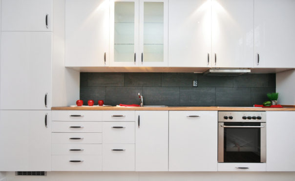 Modern kitchen with white cabinets and wood countertop