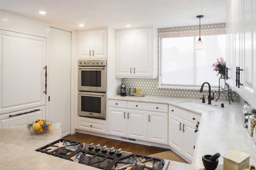 Conteporary kitchen with white cabinets and white granite countertops