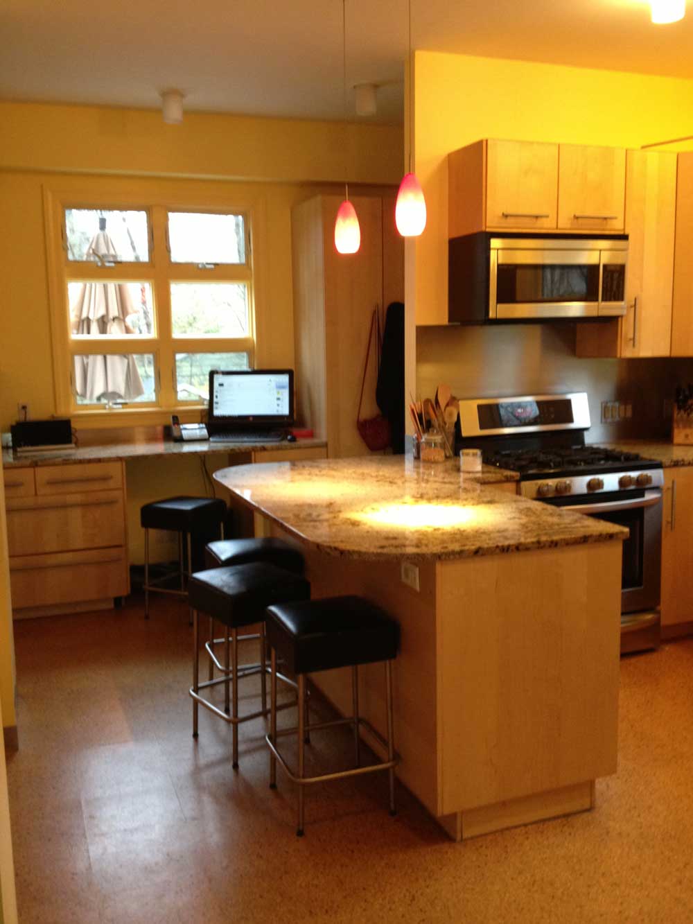 kitchen with warm wood cabinets and granite countertops, breakfast bar with black stools