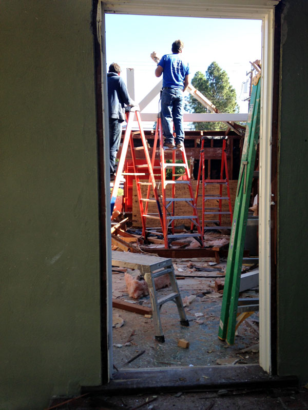 Construction worker standing on red ladder on construction site