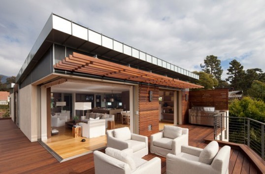 modern home with wrap-around deck and white outdoor furniture