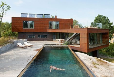 backyard of modern two-storey home with pool and woman floating