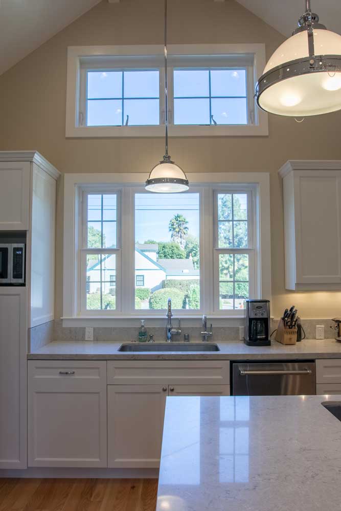 contemporary kitchen with white cabinets and granite countertops and sink under a window