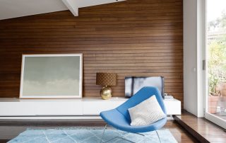 Horizontal wood panelling and blue occasional chair in mid century modern living room