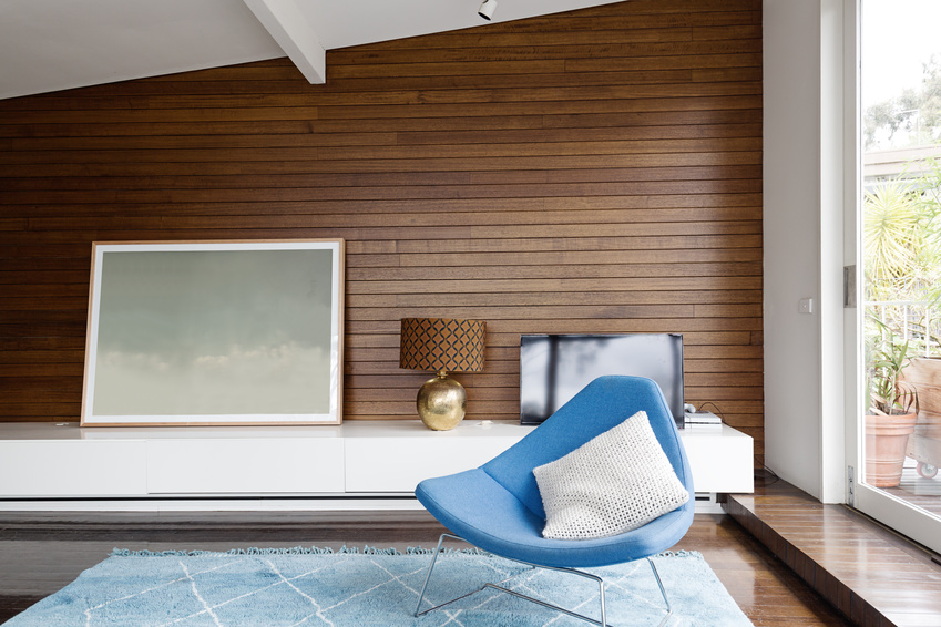 Horizontal wood panelling and blue occasional chair in mid century modern living room