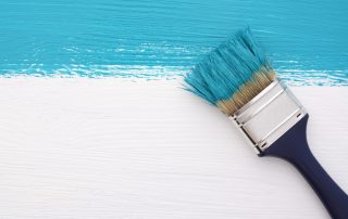 paintbrush using turquoise paint with low VOCs