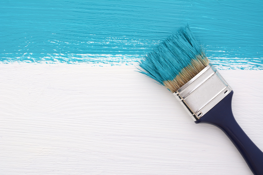 paintbrush using turquoise paint with low VOCs