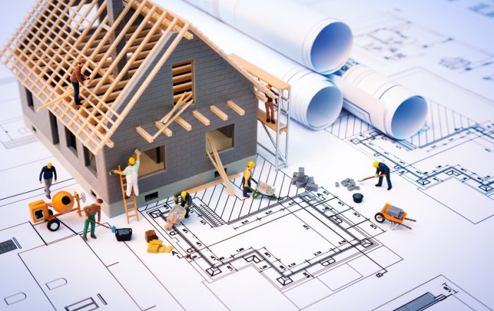 architect, contractors constructing house on blueprints