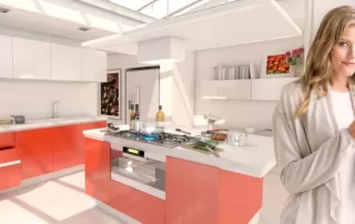 Brightly lit modern kitchen with white counters and orange cabinets. A woman stands in it with a cup of coffee.