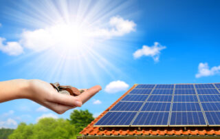 Solar panel on the roof of the house and coins in hand. The concept of money saving and clean energy.