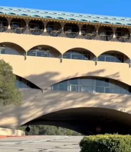 Exterior of Marin County Civic Center: beige walls and curved drive and windows with blue tile roof.