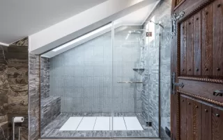 Modern, walk-in shower with grey tile and wood accents