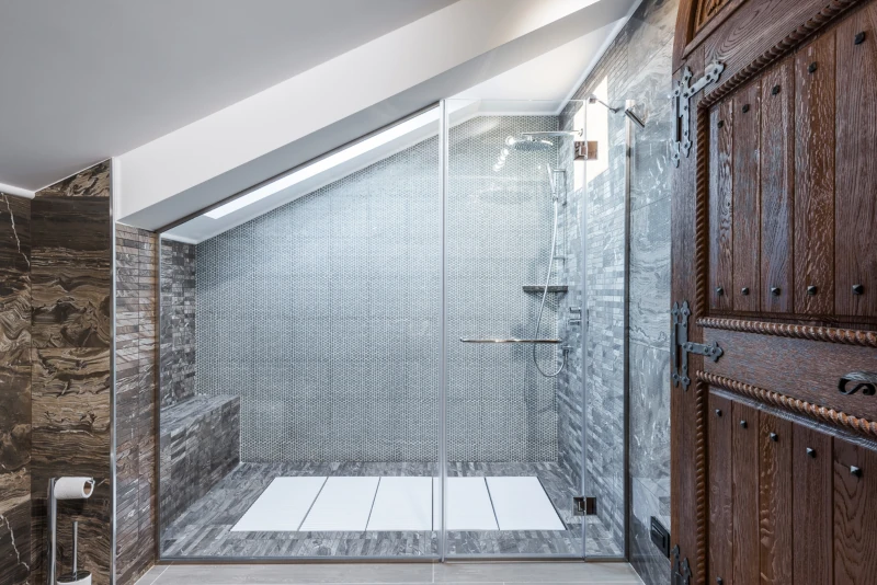 Modern, walk-in shower with grey tile and wood accents