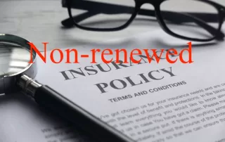 Photo of a paper that says Insurance policy, with a pair of eye glasses with the words "Non-renewed" superimposed over the image.