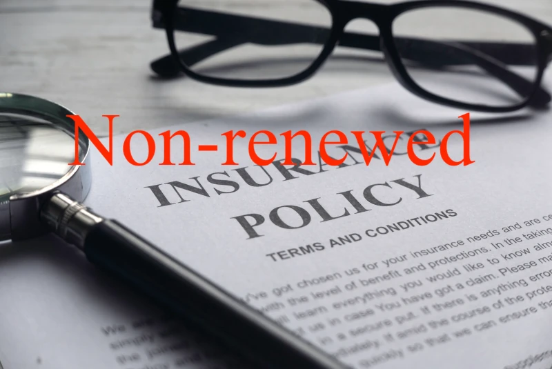 Photo of a paper that says Insurance policy, with a pair of eye glasses with the words "Non-renewed" superimposed over the image.