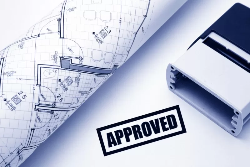 Corner of architectural plans with an "Approved" stamp.